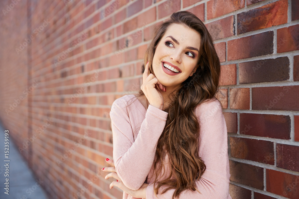 Smiling woman standing outdoors looking away Smiling woman standing outdoors looking away