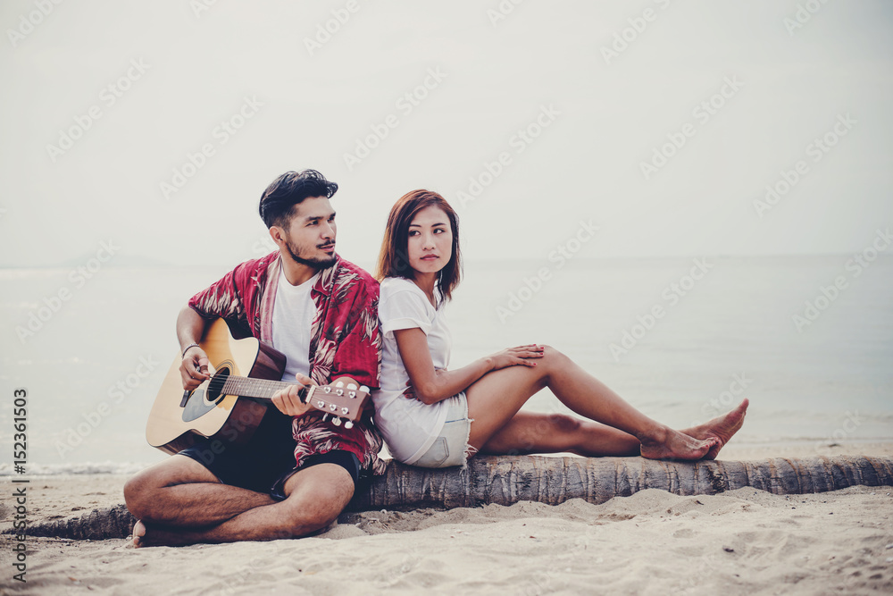 Young couples playing guitar and singing on the beach. Young couples playing guitar and singing on the beach.