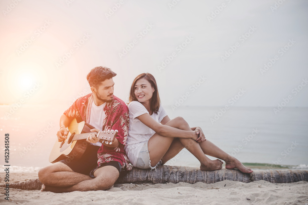 Young couples playing guitar and singing on the beach. Young couples playing guitar and singing on the beach.