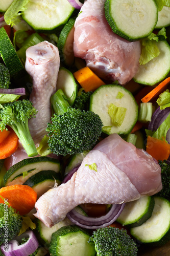 raw vegetables with chicken drumsticks, top view