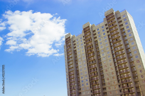 New uncompleted residential high-rise building of reinforced concrete slabs on the background of the blue sky. Social programs and affordable housing for young families Construction industry