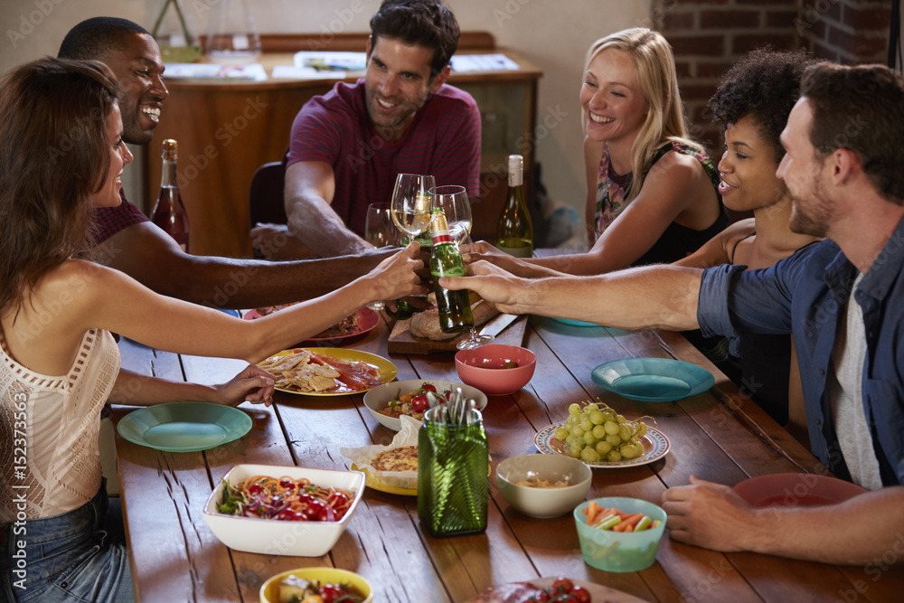 Six friends making a toast at a dinner party, elevated view Stock Photo