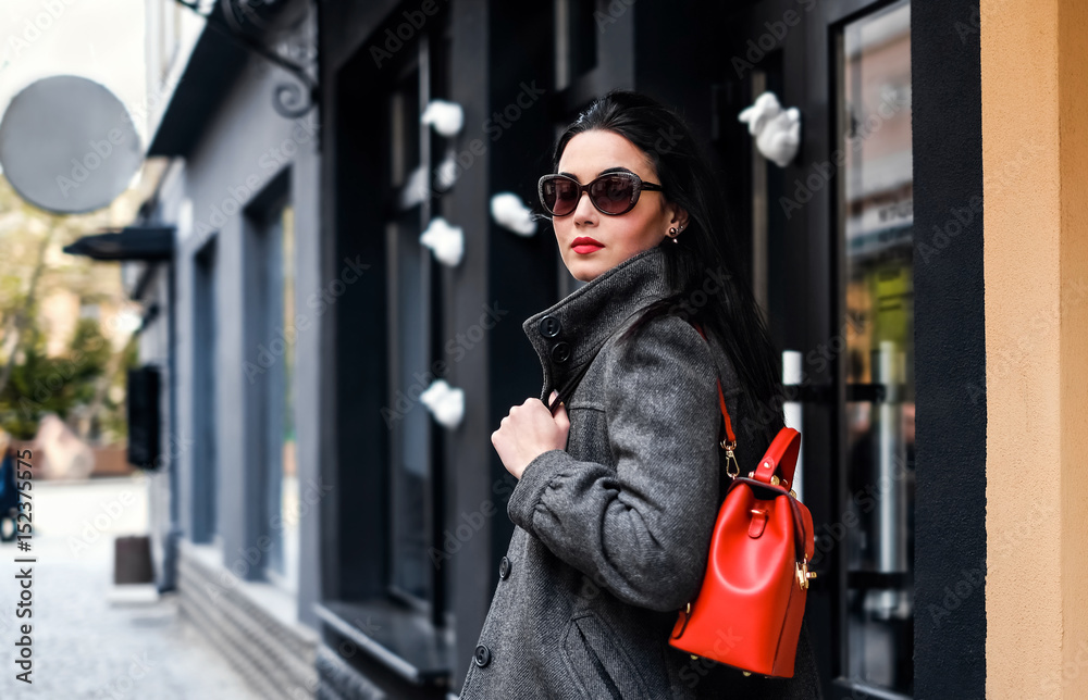 brunette girl walking on the street with red backpack brunette girl walking on the street with red backpack