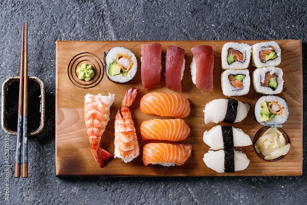 Sushi Set nigiri sashimi and sushi rolls on wooden serving board with soy  sauce and chopsticks over grey concrete background. Flat lay, space. Japan  menu Stock Photo