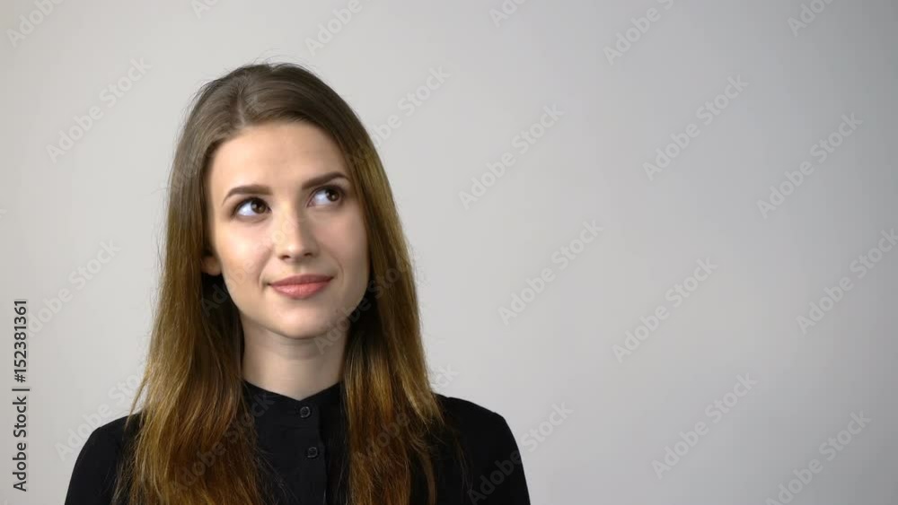 Closeup of smiling young woman looking to the side at blank copy space for text or product