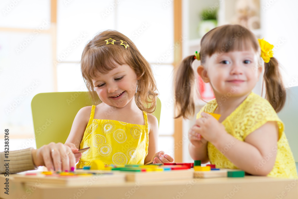 Fototapeta premium Kids children girls playing with educational child toys at home or daycare centre.