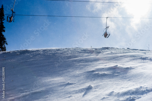 Wind blowing snow near lonely ski lift