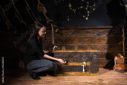 Obraz na płótnie Young girl sits near a chest and trying to find a solution of conundrum to get out of the trap w salonie