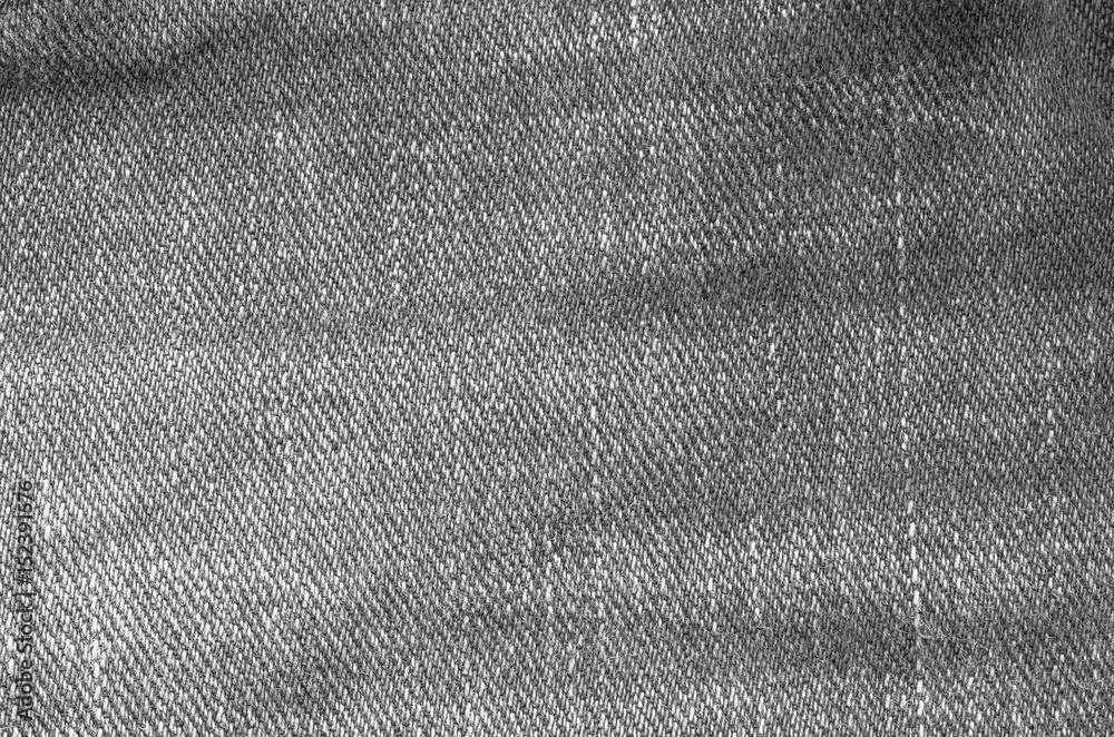 Closeup surface of old jean trousers fabric textured background in black and white tone Closeup surface of old jean trousers fabric textured background in black and white tone