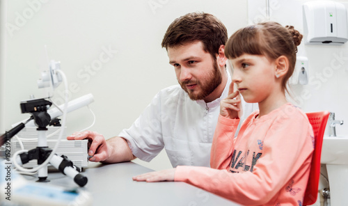 Orthoptics. Pleoptics. Doctor explains how to use ophthalmic equipment. Eye training. Vision rehabilitation. photo