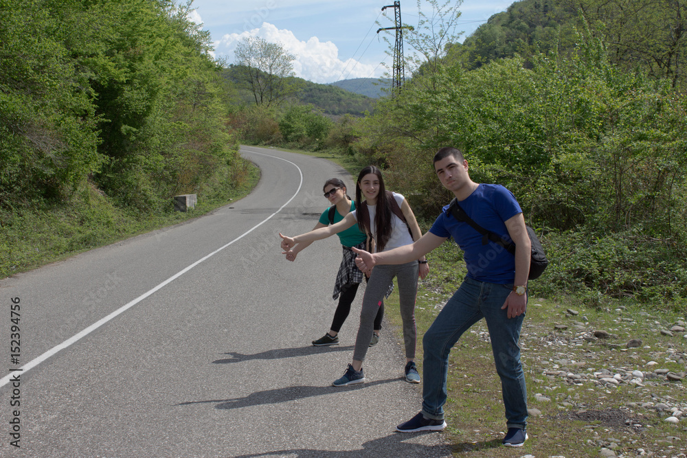 Hiking sticks near me - hitchhiking. Tourists in the road auto-stop Hiking sticks near me - hitchhiking. Tourists in the road auto-stop
