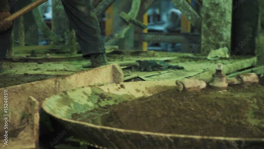 Two workers fast throw cement on metal ca Two workers fast throw cement on metal ca