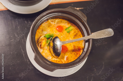 Tom yam kong or Tom yum, Tom yam is a spicy clear soup typical in Thailand and No.1 Thai Dish Cuisine. Tom yam kong on wooden table. Thai food photo
