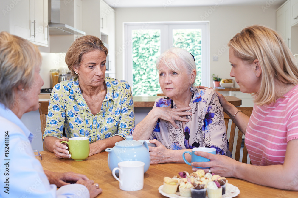 Group Of Women Consoling Unhappy Friend At Home Group Of Women Consoling Unhappy Friend At Home