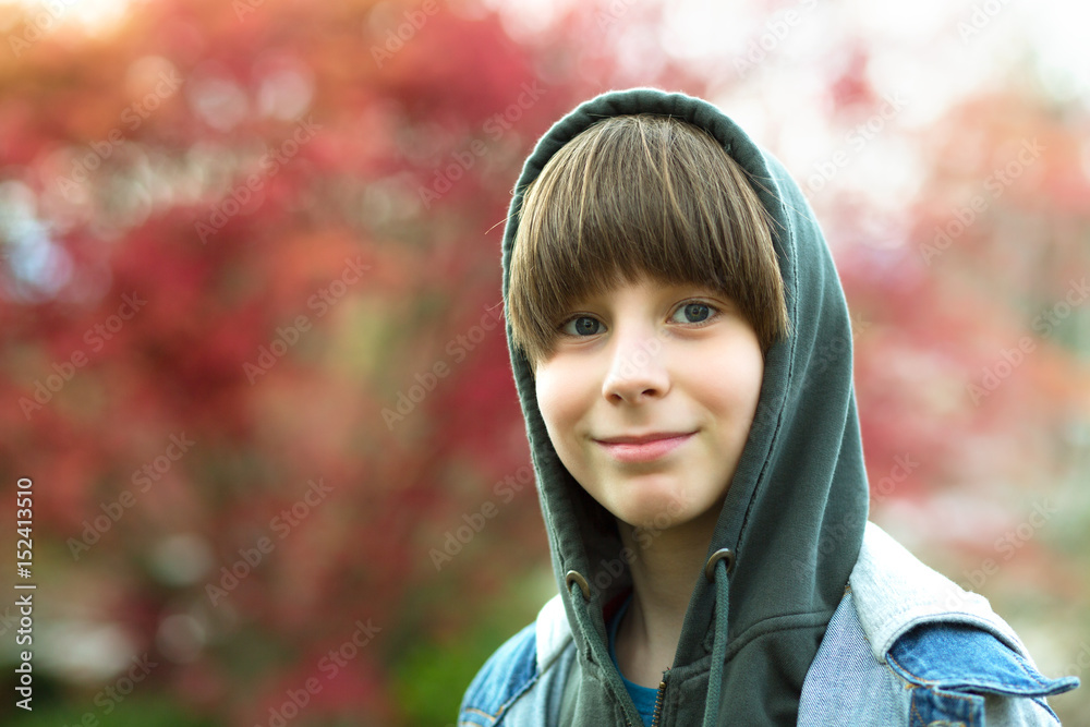 Outdoor handsome boy's portrait. Teen boy in hoodie over spring park