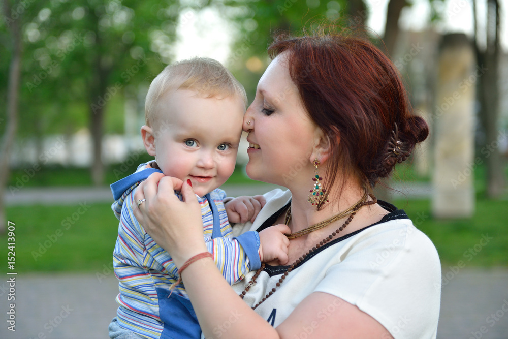 Happy mother holding her adorable little son. Family outdoor leisure. Little kid with his mom playing in park, image toned. Happy mother holding her adorable little son. Family outdoor leisure. Little kid with his mom playing in park, image toned.