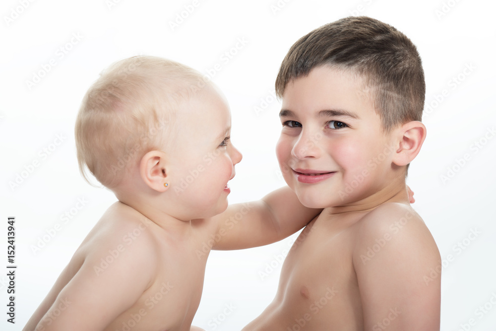 Adorable kids. Portrait of beautiful little girl embracing her brother, isolated on white background. Cute children, studio shot. Little brother and sister. Adorable kids. Portrait of beautiful little girl embracing her brother, isolated on white background. Cute children, studio shot. Little brother and sister.