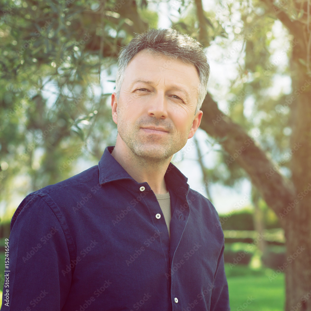 Man in olive grove, image toned. Portrait of handsome mature man lokking at camera over nature background. Man in olive grove, image toned. Portrait of handsome mature man lokking at camera over nature background.