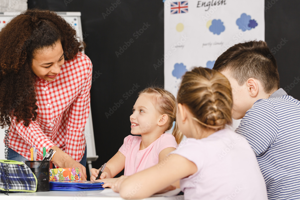 Teacher helping kids during lesson