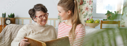 Принти на полотні Grandma and granddaughter watching photo album
