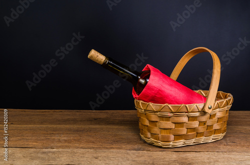 red wine bottles on wicker basket on wooden table
