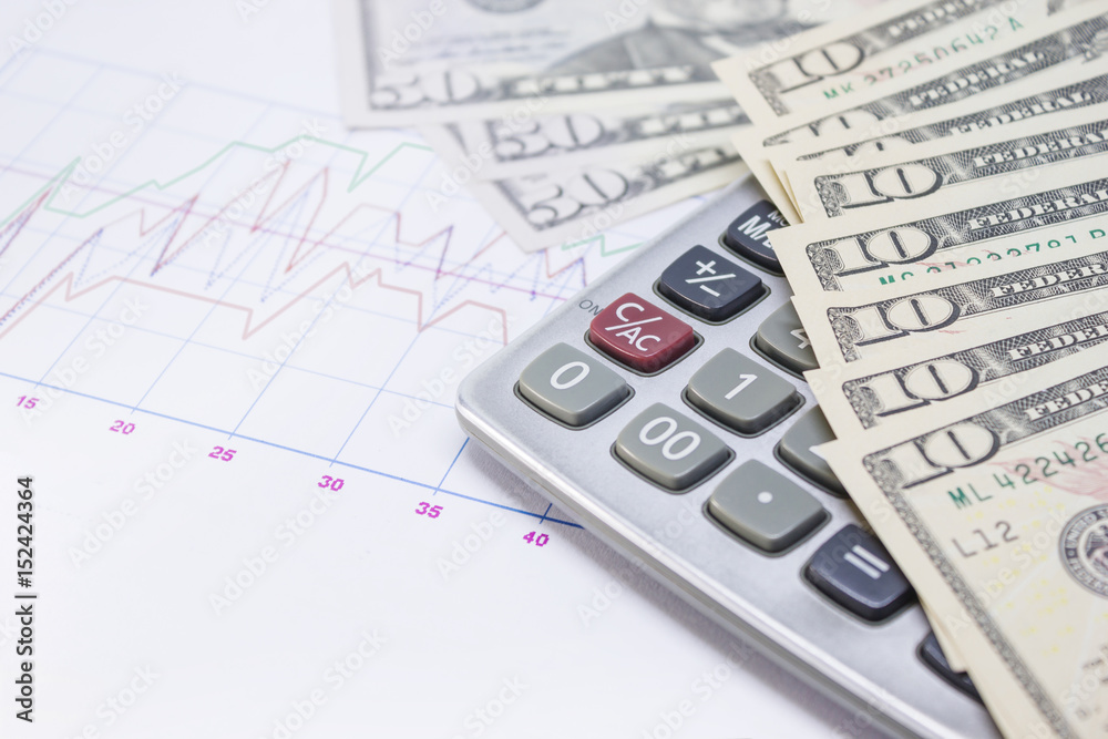 calculator, graph paper with banknotes 10 dollar, 50 dollar for business and financial concept. calculator, graph paper with banknotes 10 dollar, 50 dollar for business and financial concept.