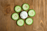 Fresh slice cucumber and sour cream sauce with dill on wooden background.
