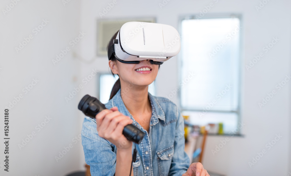 Woman play game with virtual reality device and joystick Woman play game with virtual reality device and joystick