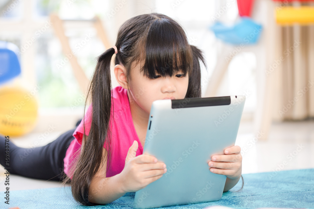 Fototapeta premium Young asian girl play the internet on a tablet computer at home