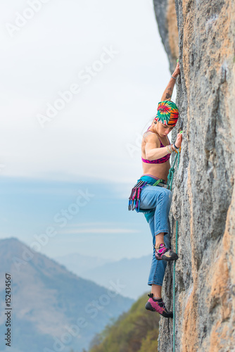 Young woman stairs a wall during a rock course
