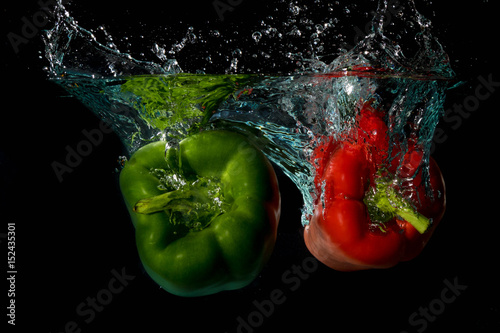 Green & Red Bell Sweet Peppers Droped Into Water
