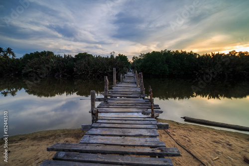 The old wooden bridge over a river at Kg. Pulau Kerengga, Marang Malaysia with sunset scenery