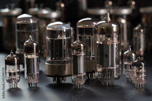Radio tubes of different shapes and sizes on a gray background
