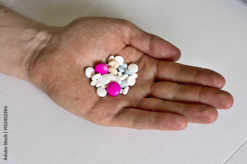 Heap of colorful medicines in his palm