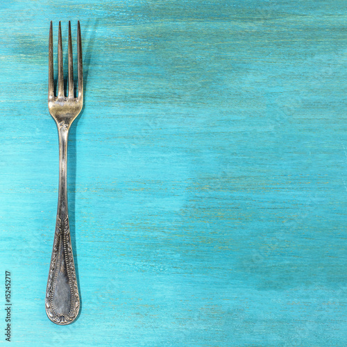 Vintage fork on vibrant turquoise with copyspace