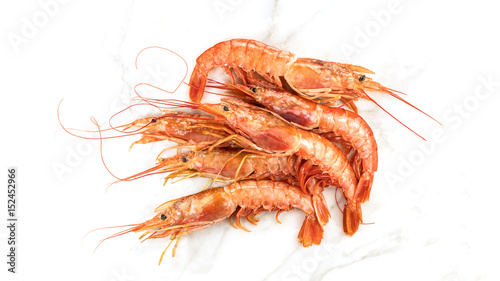 Raw shrimps on white marble table with copyspace photo