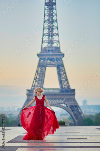 Woman in long red dress dancing near the Eiffel tower in Paris, France © Ekaterina Pokrovsky