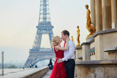 Couple kissing in front of the Eiffel tower in Paris, France