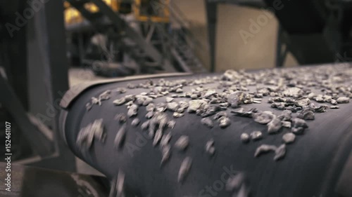 Recycling Facility.  Close-up of assembly line with metal waste on, employee sorting the wasteClose-up of assembly line with metal waste on, employee sorting the waste