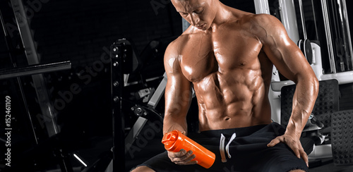 Young handsome guy doing exercises in the gym