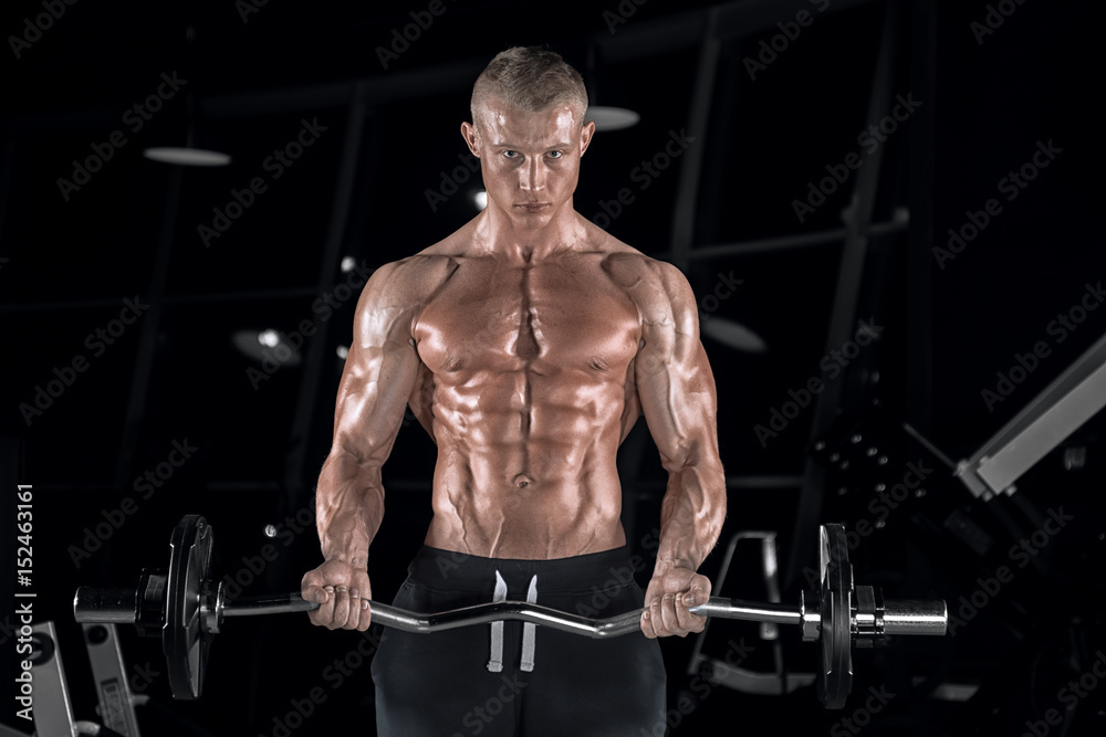 Young handsome guy doing exercises in the gym Young handsome guy doing exercises in the gym