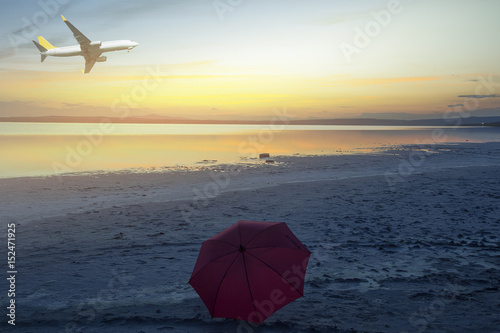 Airplane flying over tropical beach with smooth wave and sunset sky abstract background. Copy space of business summer vacation and travel adventure concept.