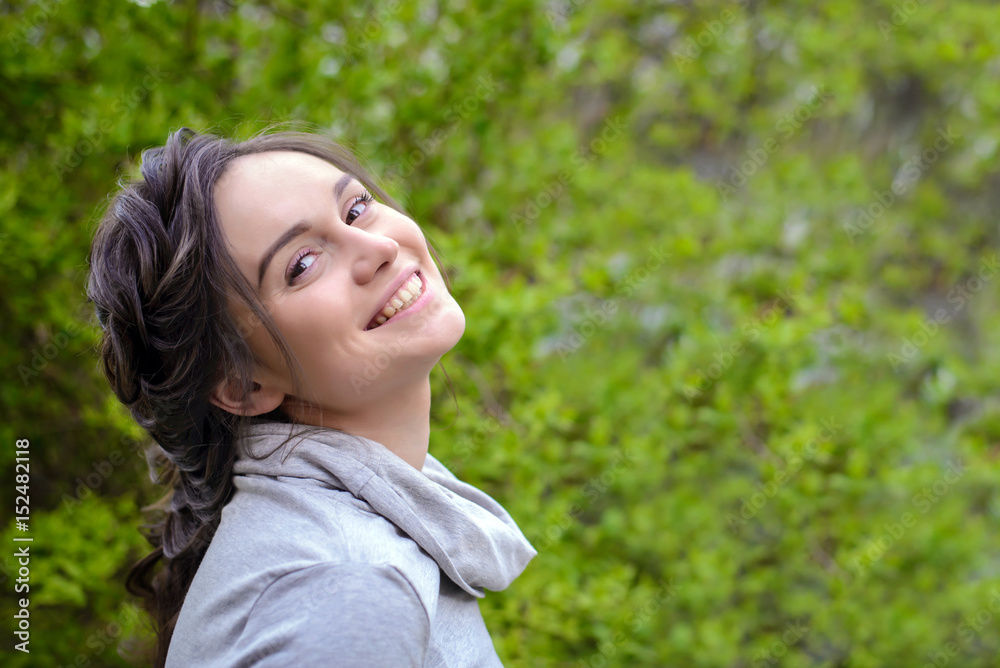 Portrait of a beautiful girl on a background of green foliage Portrait of a beautiful girl on a background of green foliage
