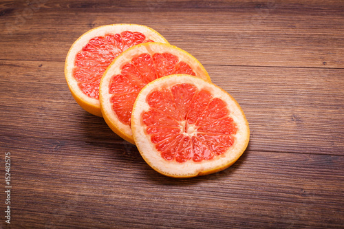 orange grapefruit on a wooden surface. arrangement of sliced fruit.