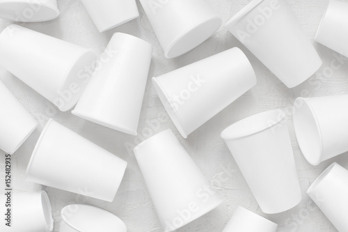 Scattered styrofoam empty cups on the white textured table