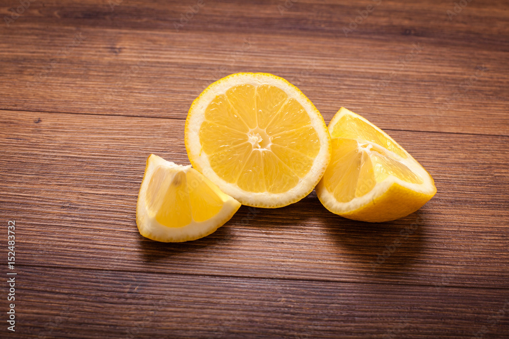yellow lemon on a wooden surface. arrangement of sliced fruit yellow lemon on a wooden surface. arrangement of sliced fruit