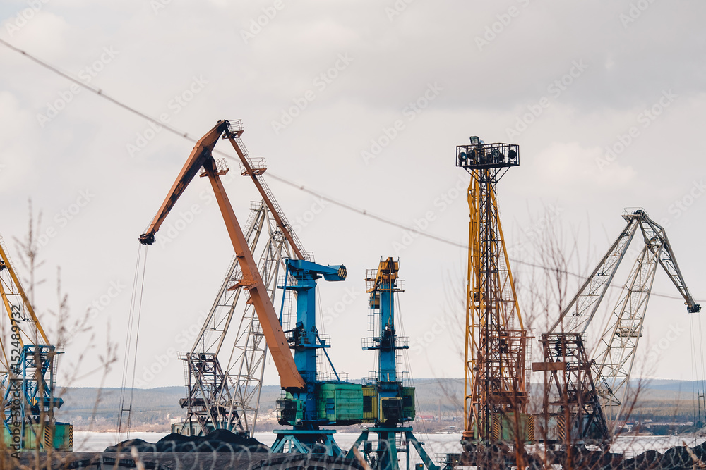 MURMANSK, RUSSIA. Embankment along with the river port, the crane unloads coal