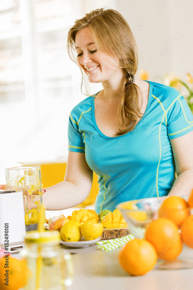 Sportliche frau in der küche (smoothie mixen) Sportliche frau in der küche (smoothie mixen)