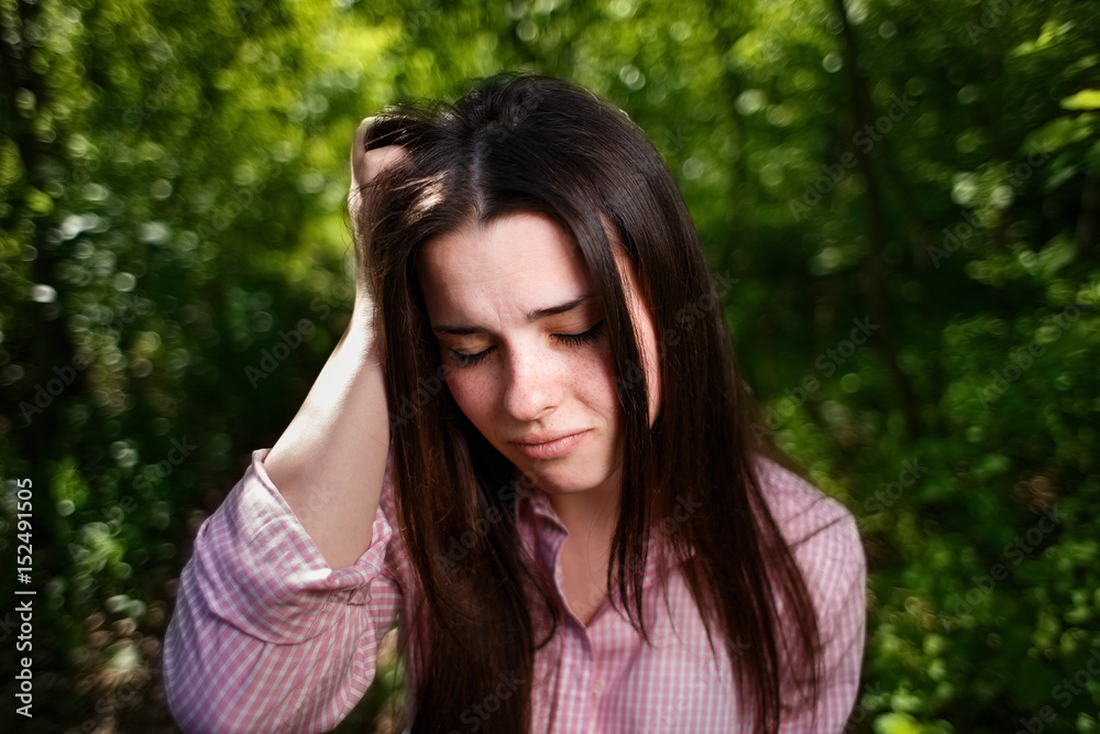 Portrait of young stressed woman suffering from headache or migraine