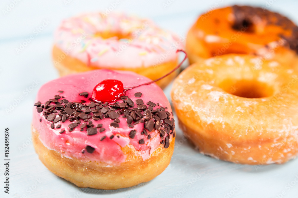 Different donuts on light blue background. Close up image with selective focus Different donuts on light blue background. Close up image with selective focus